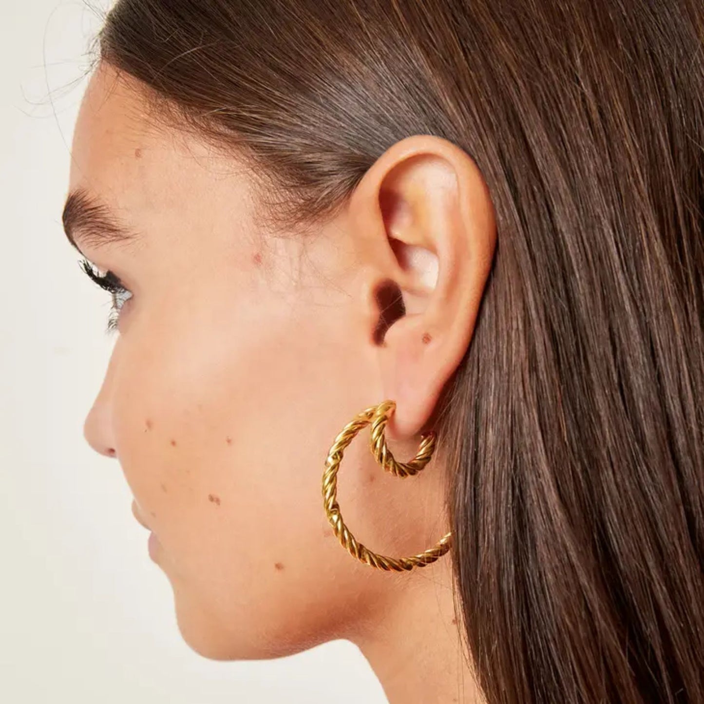 Model wearing the Gold Twisted Hoop Earrings by Scott-Samuel