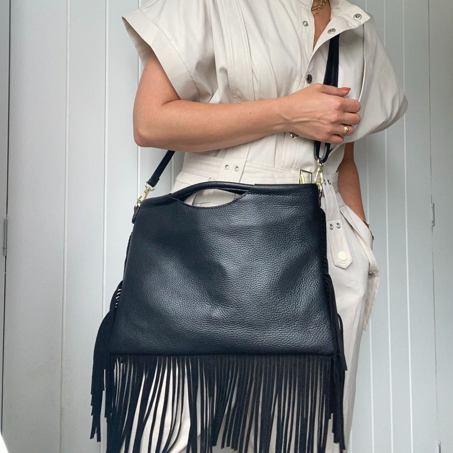 Model wearing the fringed bag with the adjustable leather strap.