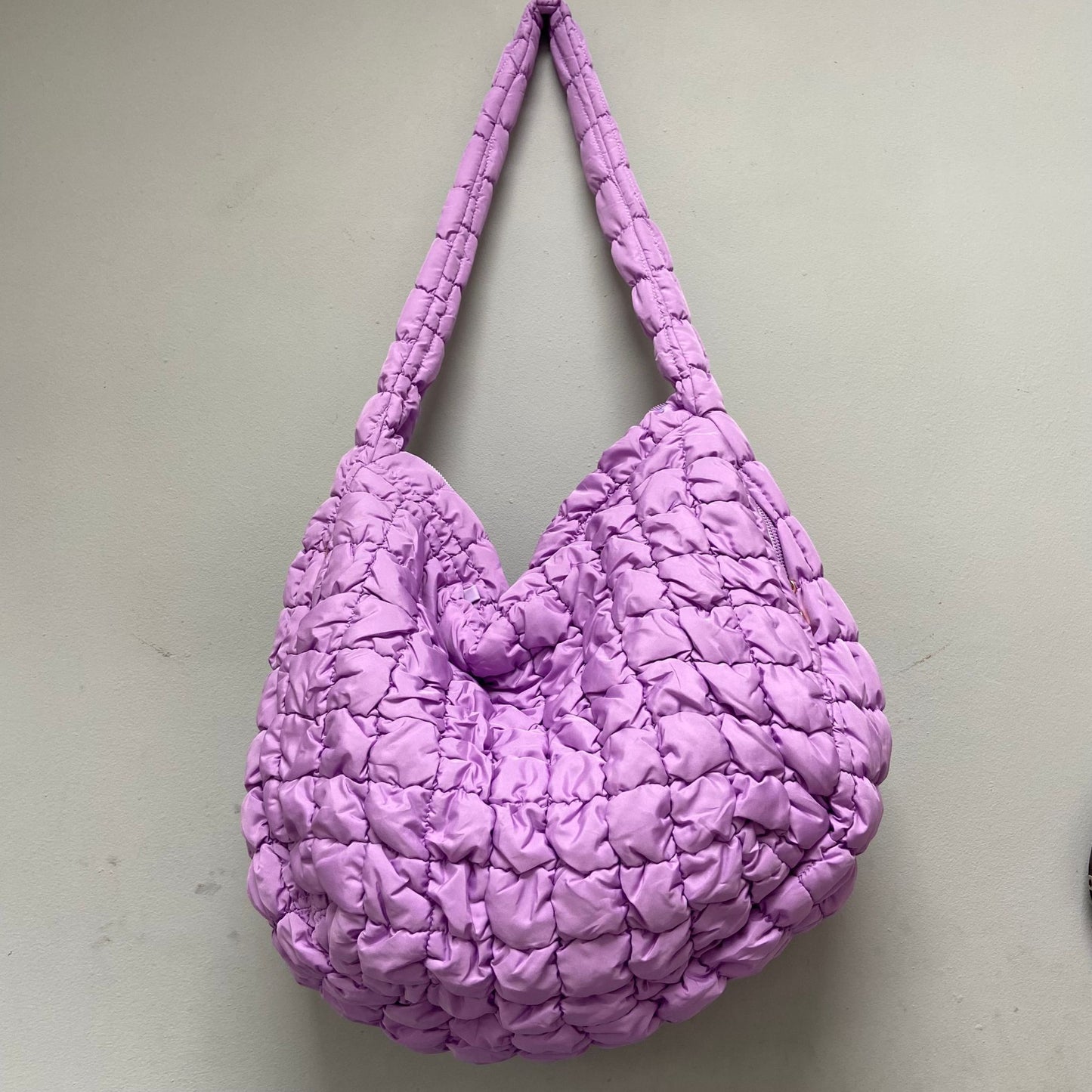 Stylish quilted bag featuring convenient zippered pockets for phone and keys