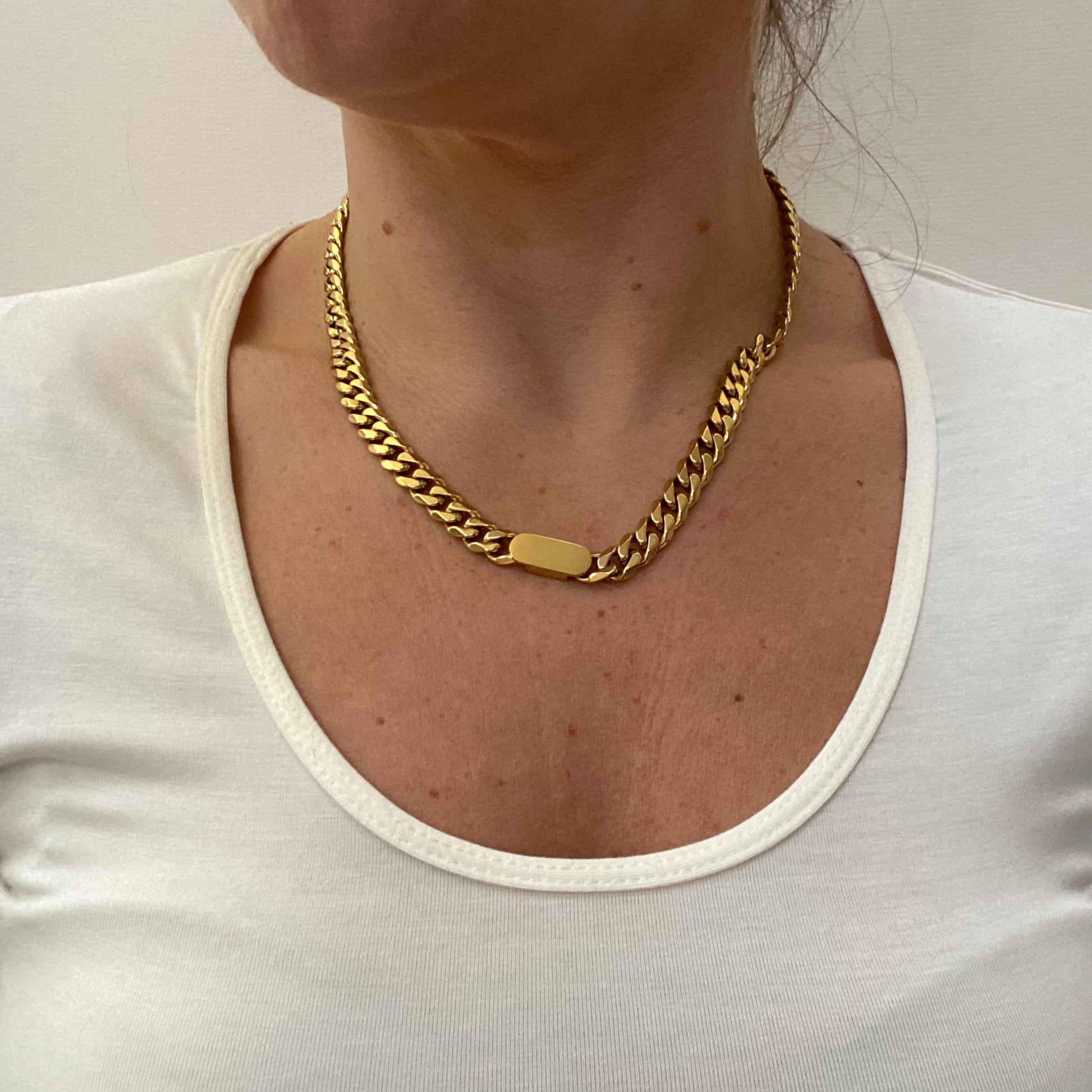Model wearing a matching chunky gold chain necklace .