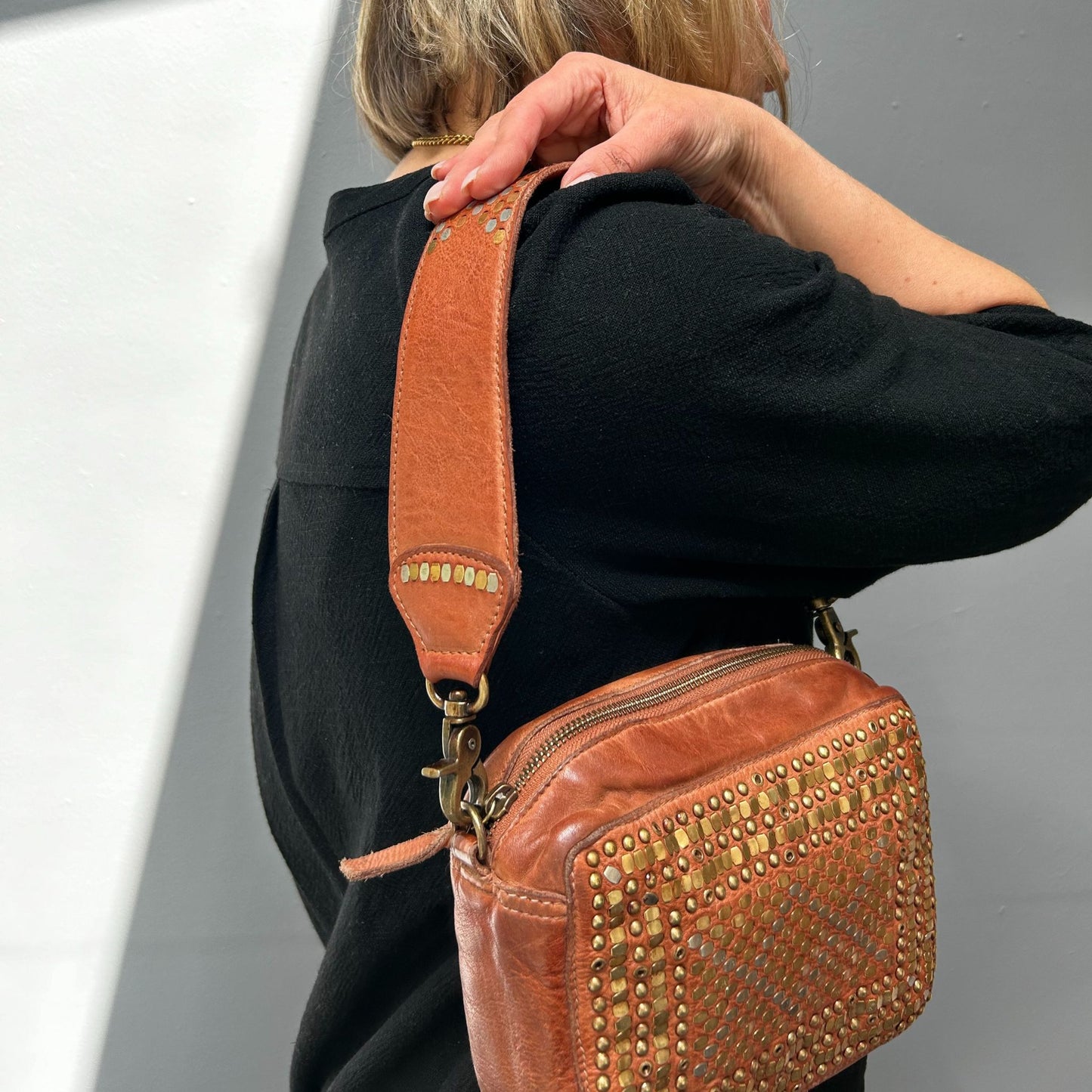 Person wearing the Scott-Samuel woven leather crossbody bag in brown over the shoulder