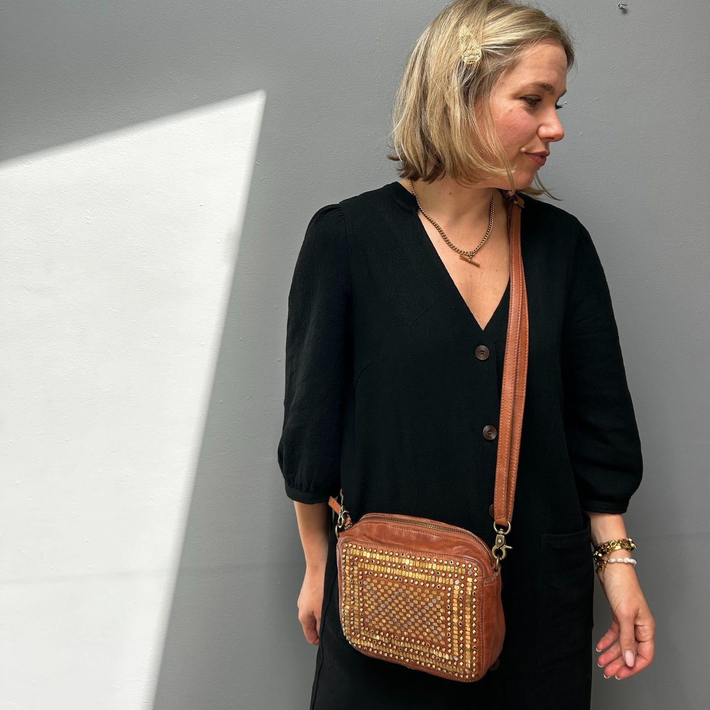 Close-up of the Scott-Samuel woven leather crossbody bag in brown being worn over the shoulder.
