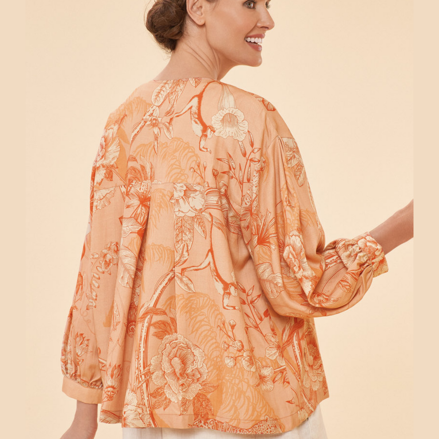 Model showcasing the side view/back view of the Coral Puff Sleeve Jacket,