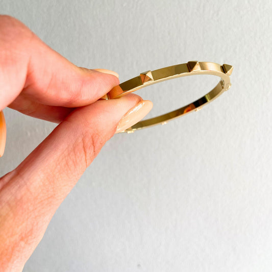 Hand holding the Gold Studded Bangle by Scott-Samuel