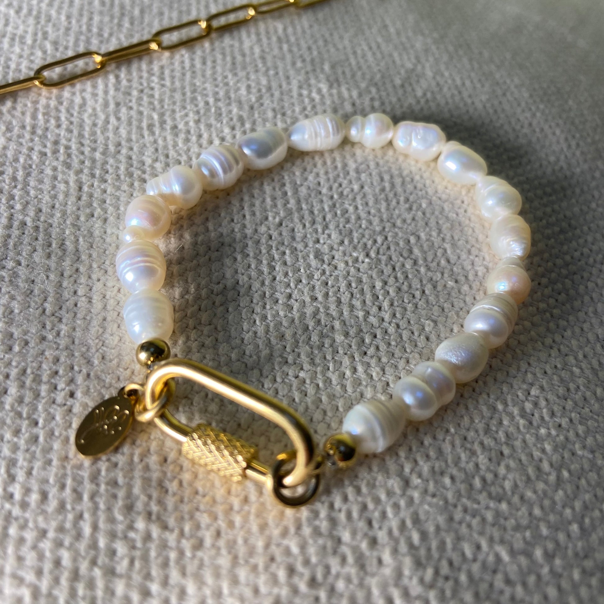 Freshwater Pearl Bracelet with oval gold clasp displayed on a textured background