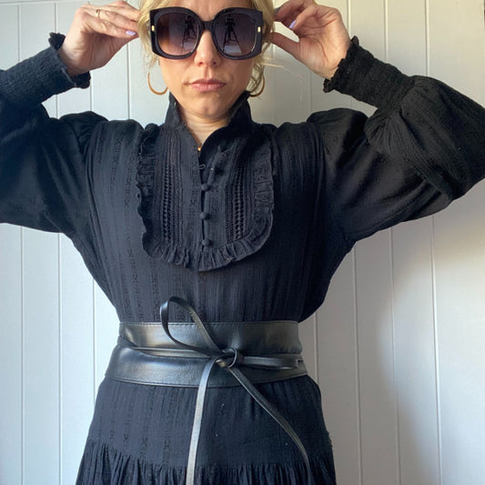 Woman wearing a black dress with a black Obi Leather Wrap Belt tied at the waist.