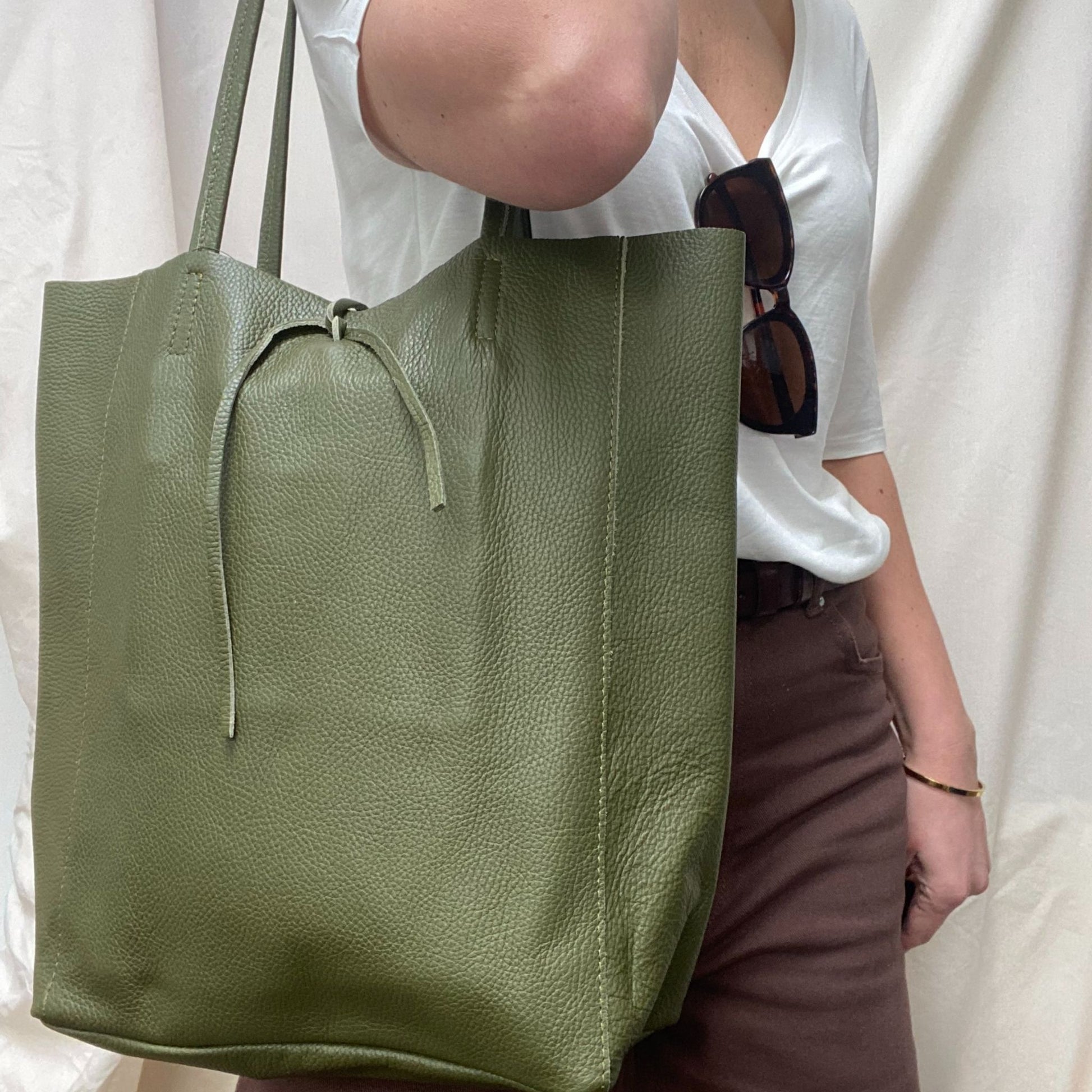 Lady holding green leather bag side view