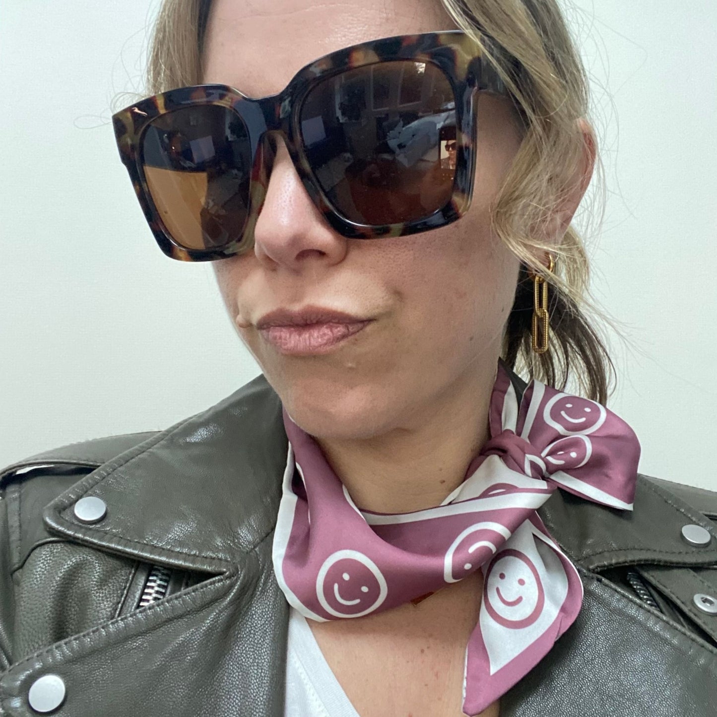 pink smiley face scarf with leather jacket