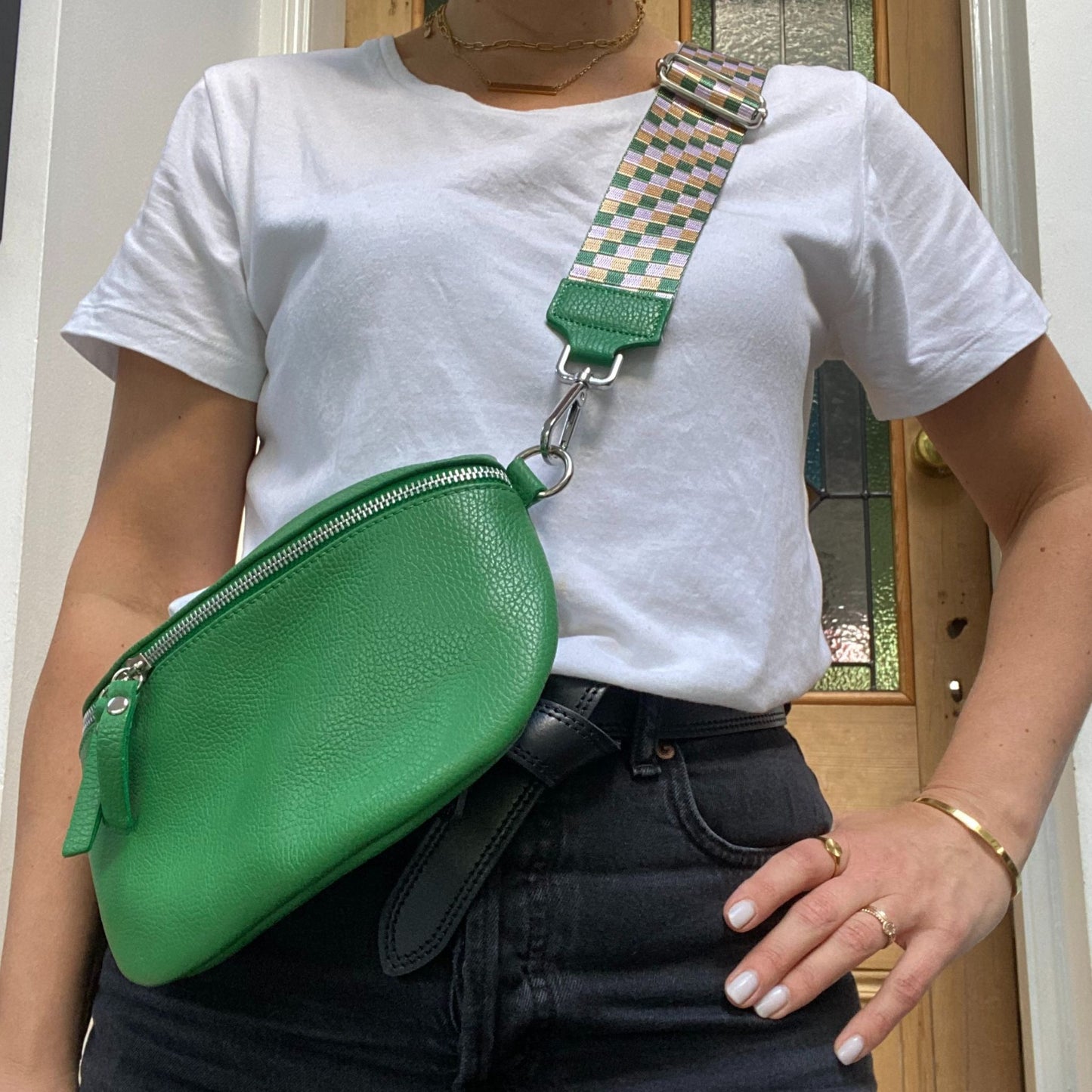 green bumbag with checkerboard strap